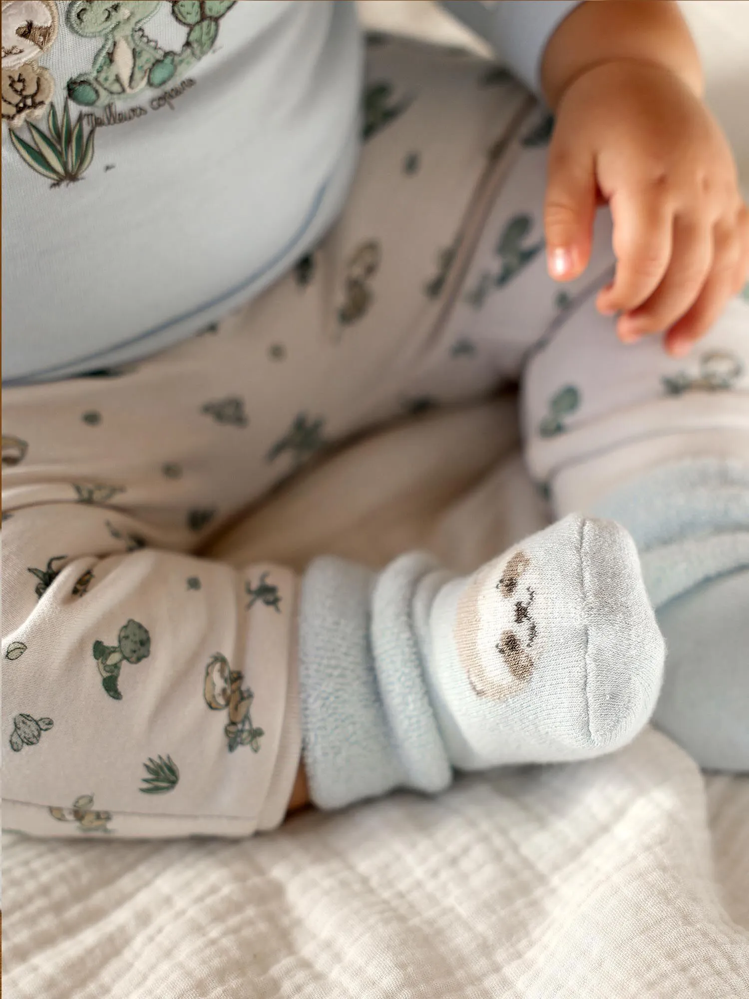 Body-T-shirt bleu, pantalon beige et chaussettes vert d'eau