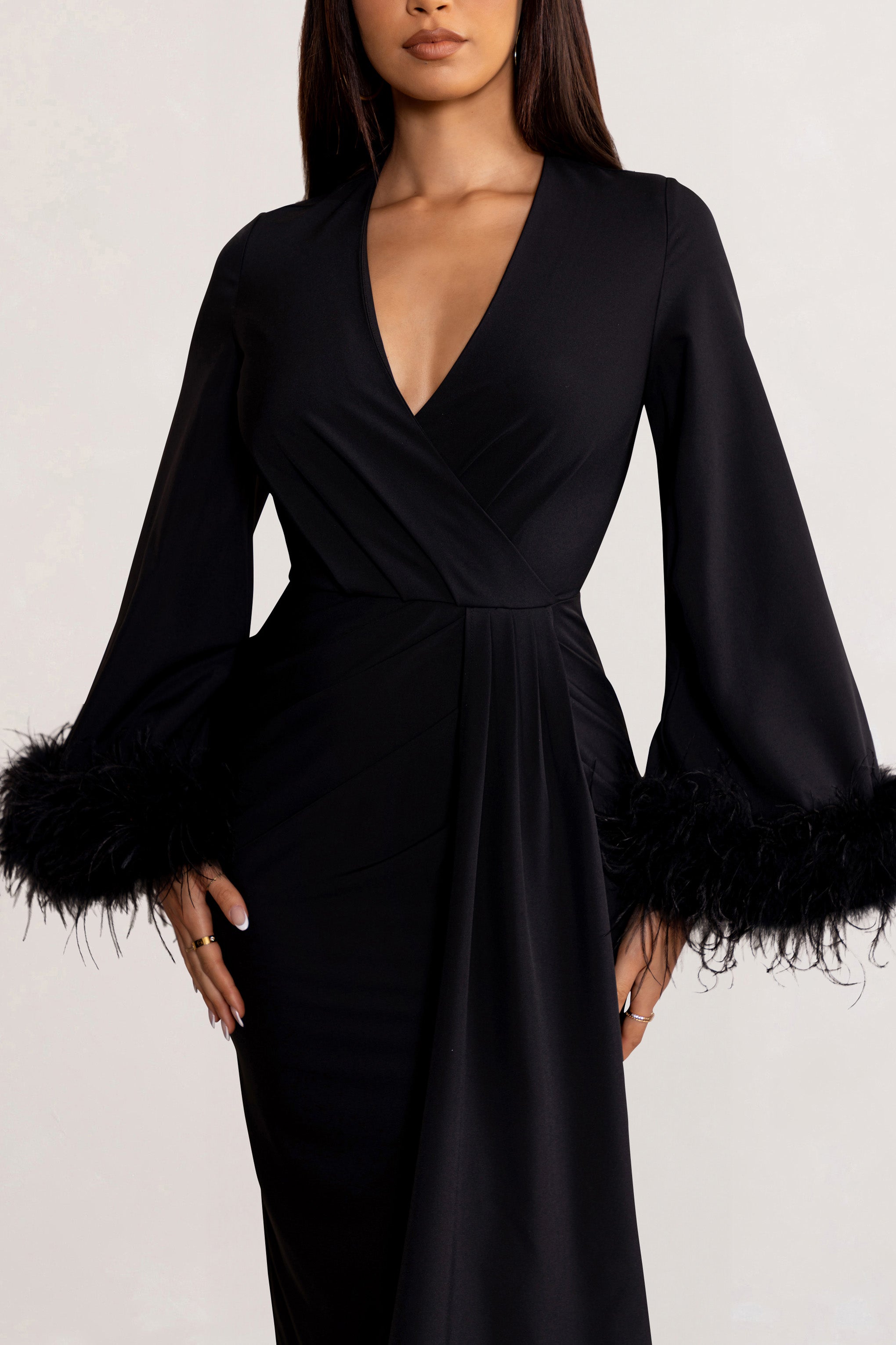 Jenna | Robe mi-longue noire à décolleté plongeant avec manches larges bordées de plumes et drapé à nouer sur le devant